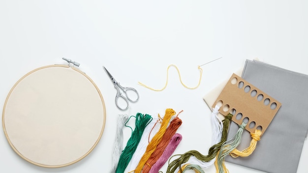Colorful embroidery threads and tools on wooden table